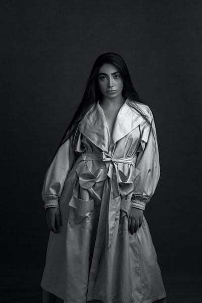 A woman standing in a gray coat
